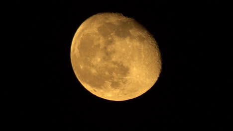 Extreme-Nahaufnahme-Des-Orangefarbenen-Mondes-Im-Dritten-Viertel-In-Einer-Klaren-Nacht