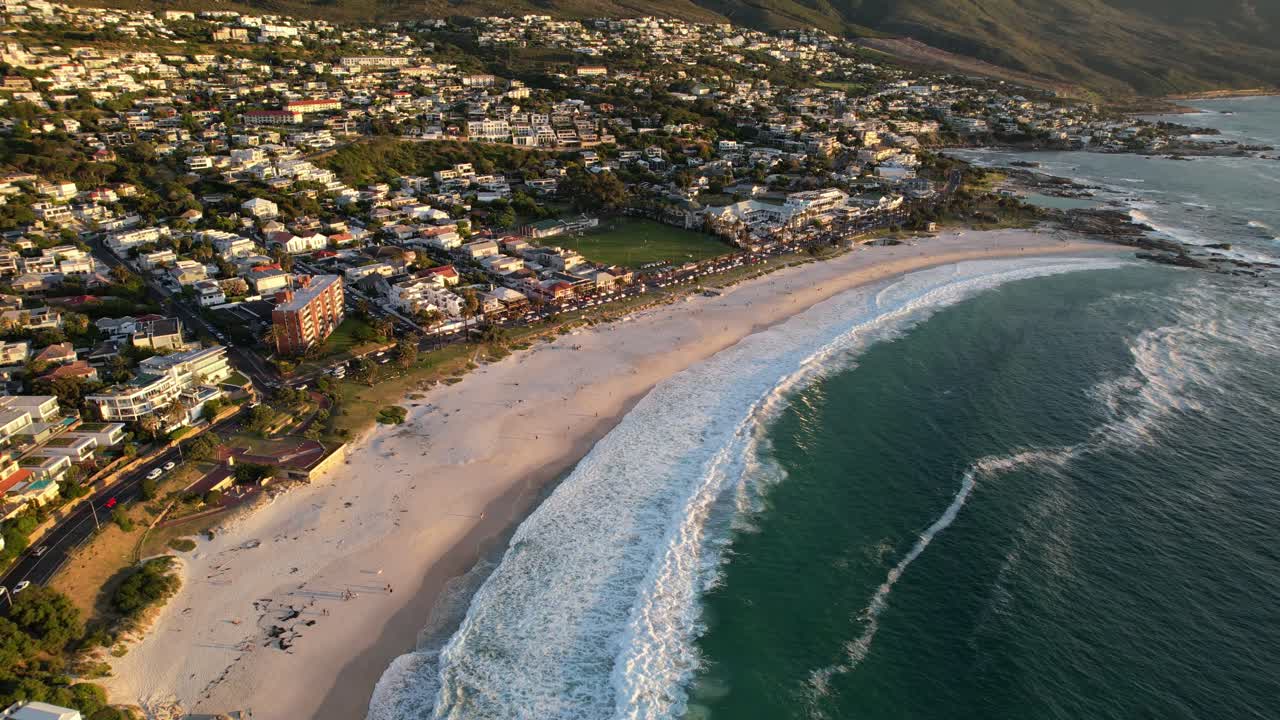hermosa costa de la playa de camps bay durante la puesta de sol revelando doce apóstoles en ciudad del cabo, aéreo