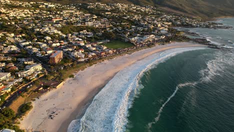 Beautiful-coastline-of-Camps-Bay-Beach-during-sunset-revealing-Twelve-Apostles-in-Cape-Town,-aerial