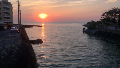 river mouth at ocean with sunset in background