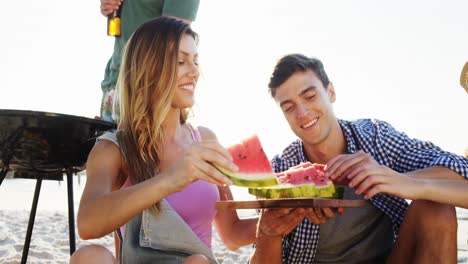 friends having watermelon on the beach 4k