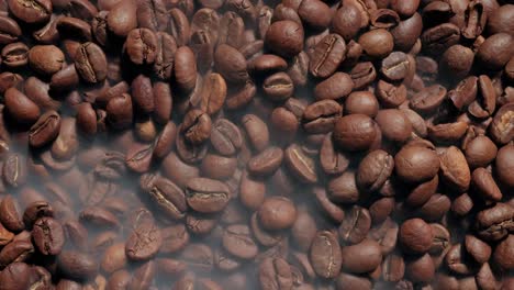 cerca de las semillas de café. los granos de café perfumados son tostados el humo viene de los granos de café.