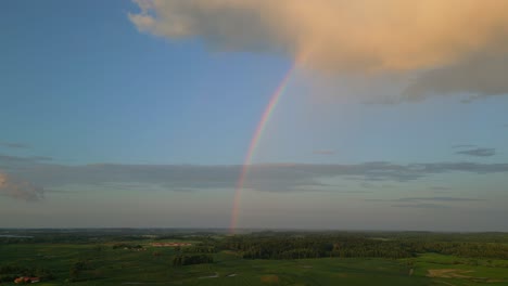 Aerial-shot-of-the-landscape-from-which-the-rainbow-rises-to-the-sky