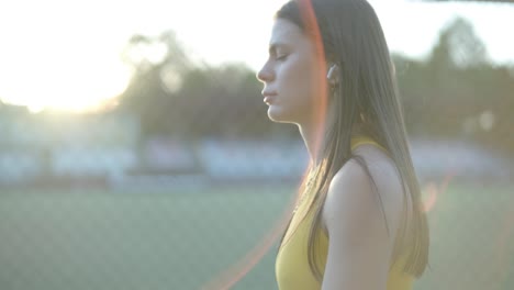 mujer corriendo en una pista al aire libre con ropa deportiva amarilla