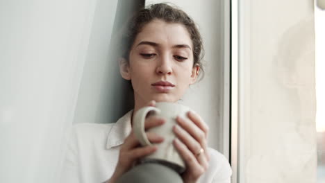 girl with coffee mug by window