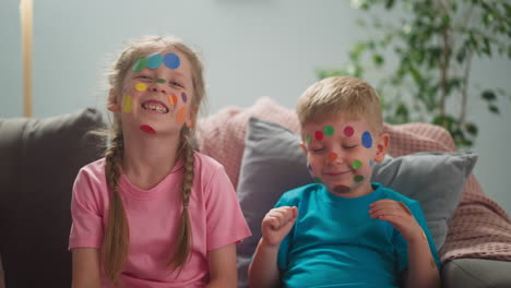 little girl and toddler brother with dot stickers on faces