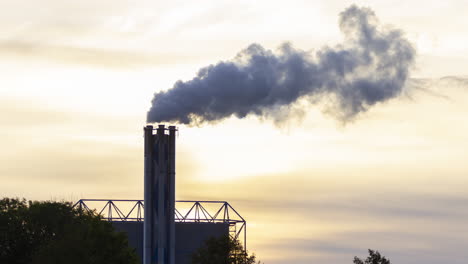 Lapso-De-Tiempo-De-La-Chimenea-De-La-Fábrica-Humeante-Contra-El-Fondo-De-Un-Sol-Poniente---Cultivo