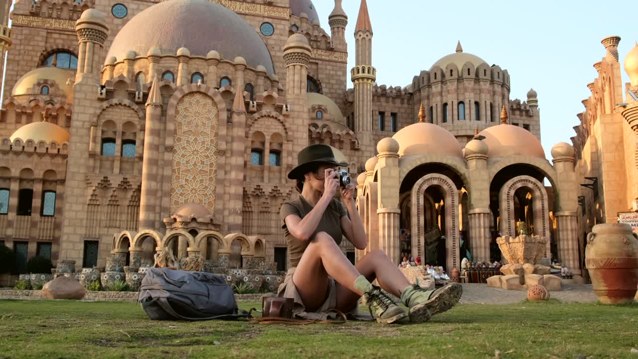 chica al estilo vaquero se sienta en la hierba, con el teléfono.mosque.egypt
