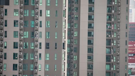 condominium building panning upward in bangkok, thailand with windows on the side of the building