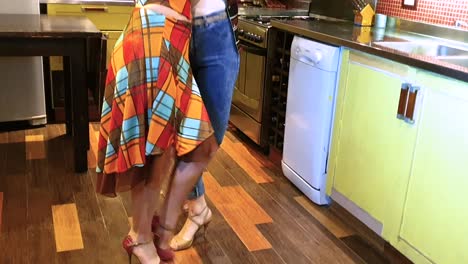 a loving lesbian couple shares a romantic dance in a cozy kitchen