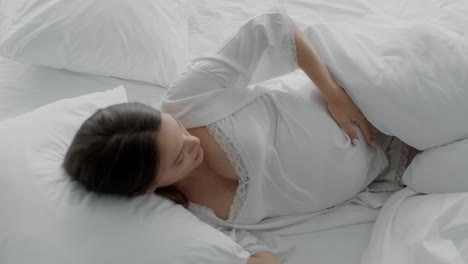 mujer embarazada durmiendo cómodamente en la cama