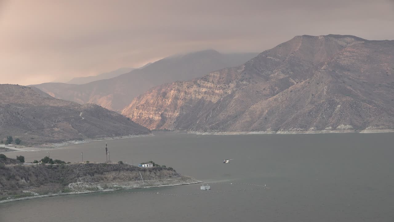 브러시 파이어 홀저 화재 후 헬리콥터 리필 물방울이 캘리포니아 피루 호수 근처의 언덕을 태운다.