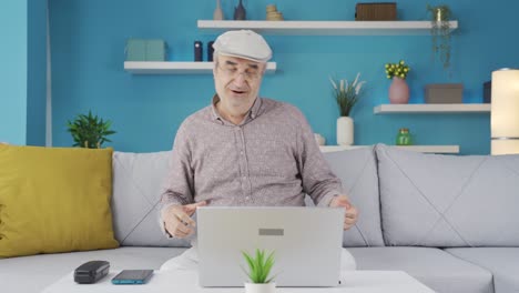 Funny dancing old man at the laptop.