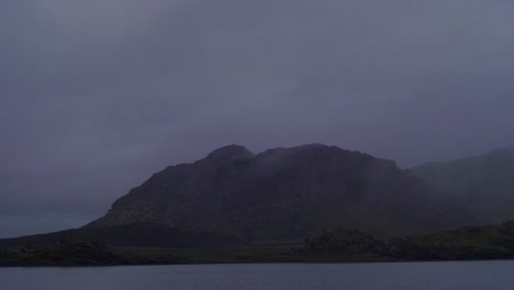 dramatic iceland landscape at night, mountain lake, camera pan from left to right