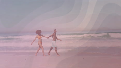 couple walking barefoot along shoreline in marketing ad, with animated wave chart and compass icons