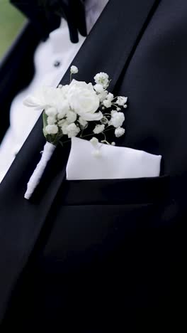 the groom touching the boutonniere flower