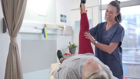 fisioterapeuta caucásica estirando la pierna protésica de una paciente en el hospital
