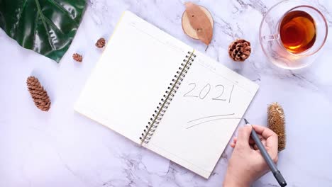 hand writing 2021 on notebook