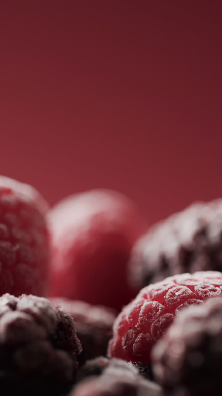 Micro vertical video close up of raspberries and copy space on red background