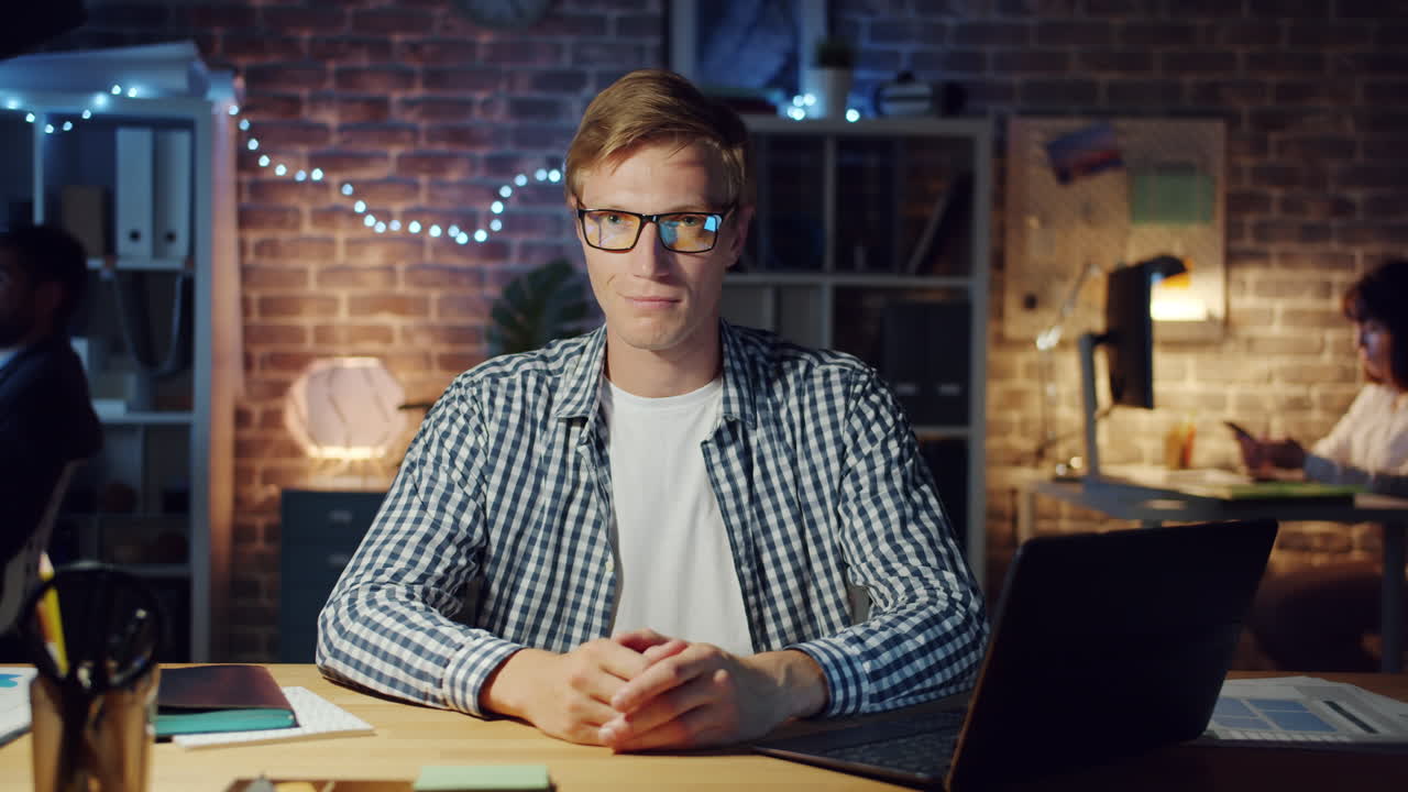 Mężczyzna pracujący do późna w nocy na laptopie w biurze