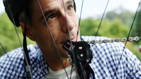 man repairing their bicycle in the park