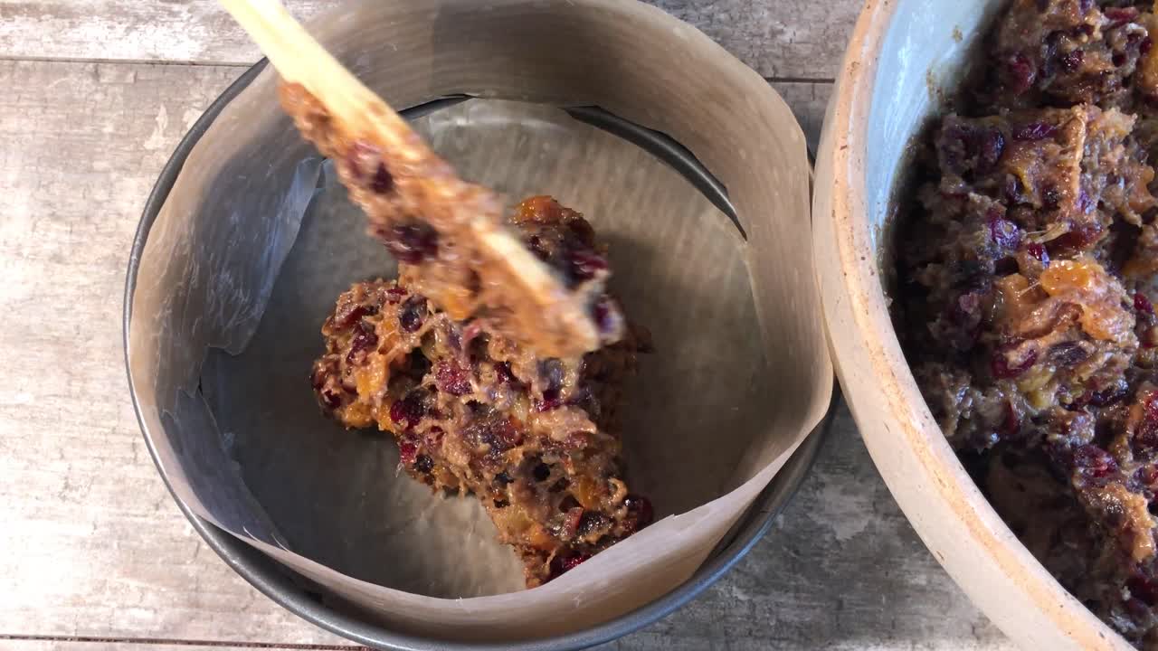 베이킹 팬 평면도에 과일 케이크 반죽을 스푼