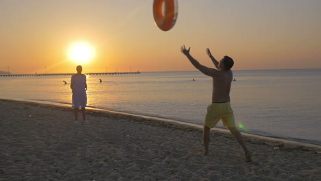 Pareja-Joven,-Juego,-Con,-Anillo-De-Goma,-En-La-Playa