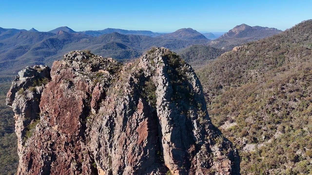 Ripresa con drone di cime montuose frastagliate e della vasta natura selvaggia dell'outback nel Parco Nazionale Warrumbungle, Australia.