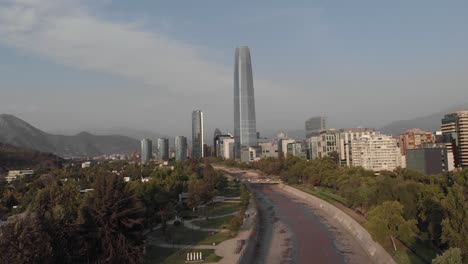 santiago skyline seen as aerial descends to urban mapocho river bridge