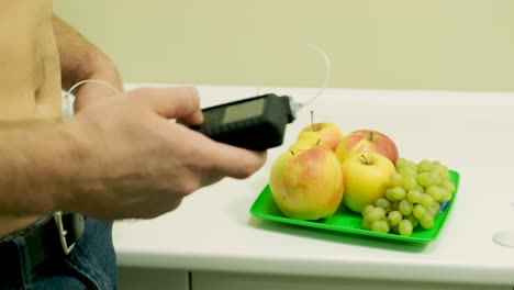 diabetic man with an insulin pump connected in his abdomen and holding the insulin pump at his hands. diabetes concept.