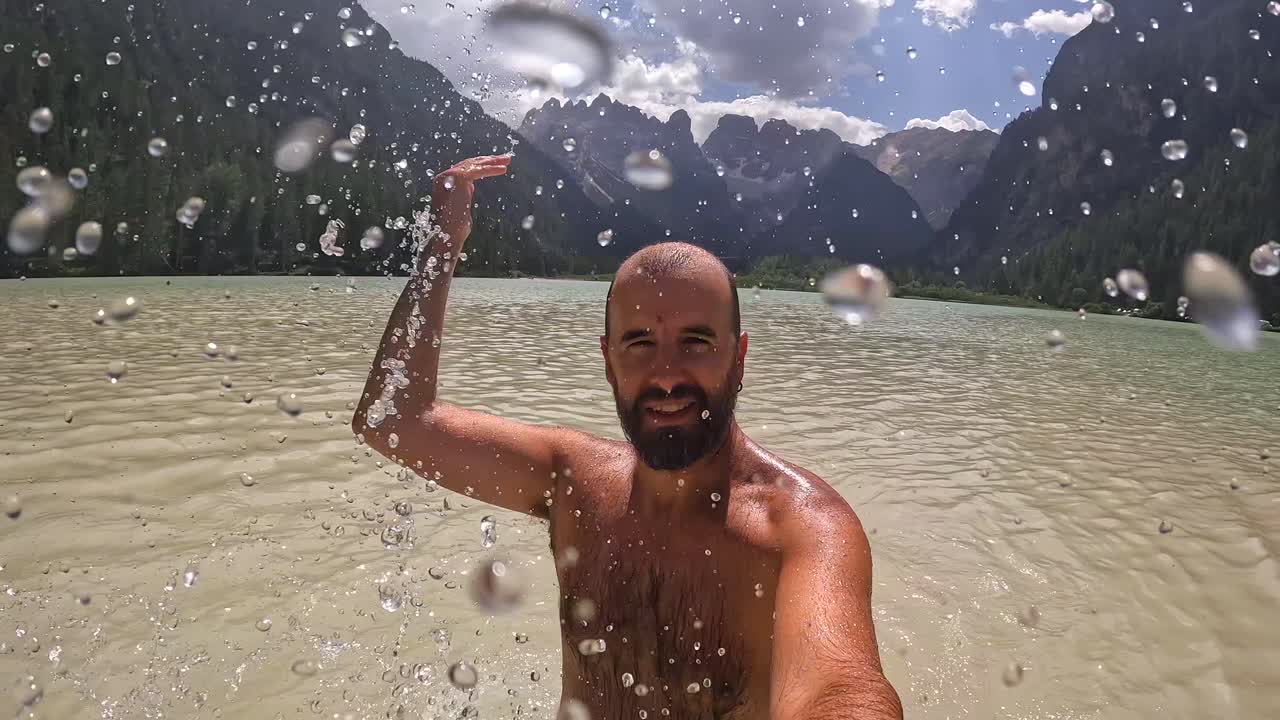 Turista che si gode le vacanze estive nuotando nel lago di Landro nelle Dolomiti, Italia