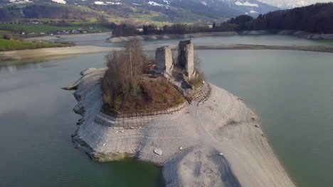 aerial circling over old ruins of pont en ogoz castle on gruyere lake