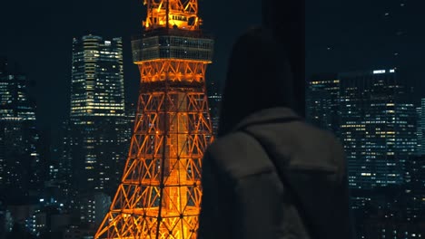a serene moment of a girl gazing at the illuminated tokyo tower surrounded by the dazzling city skyline at night.