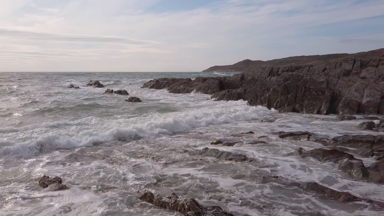 olas rompiendo en una cala rocosa en devon durante la puesta de sol en cámara lenta