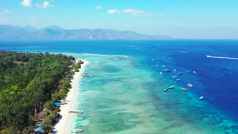 Peaceful-scenery-of-tropical-beach-with-white-sand-washed-by-calm-turquoise-lagoon-full-of-anchored-boats-waiting-to-start-touring-toward-blue-sea