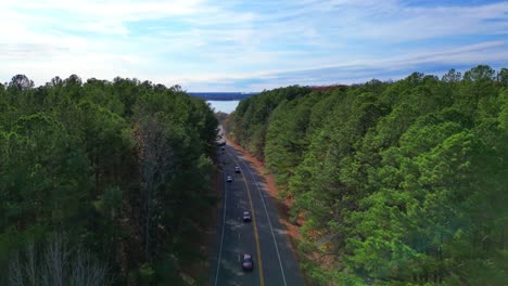 Aerial-view-of-cars-driving-on-a-2-lane-highway,-with-beautiful-Paris-Landing-in-the-background