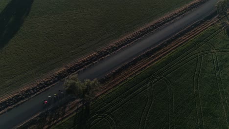 aerial view of a small group of cyclist riding along country roads with lush green crop fields in the rural city of wagga wagga nsw australia.