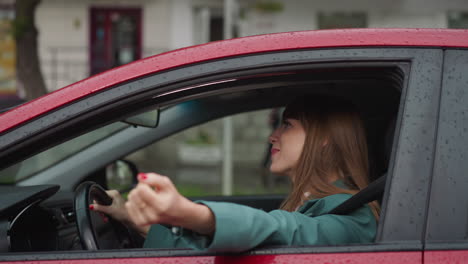 cheerful woman smiles stretching hand out of car window