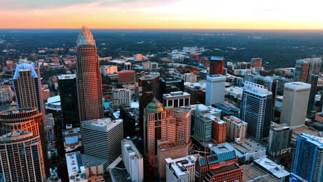 buildings in the city uptown lit with orange light at sunset. scenery of american city of charlotte, nc, usa from top