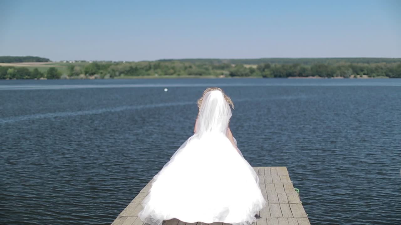 Wedding Bride Walking. Bride walking along lake coast wearing beautiful wedding dress