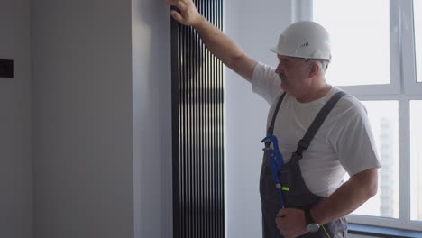 a man plumber checks the batteries and heating system. heating season