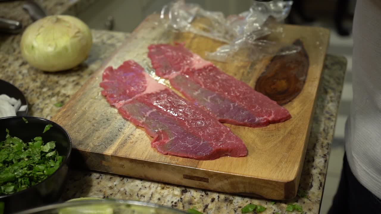 Laying Out Steak on a Wooden Cutting Board in Slow Motion.