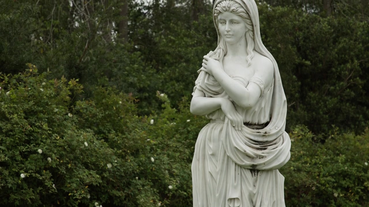Garden statue of a woman as camera pans up
