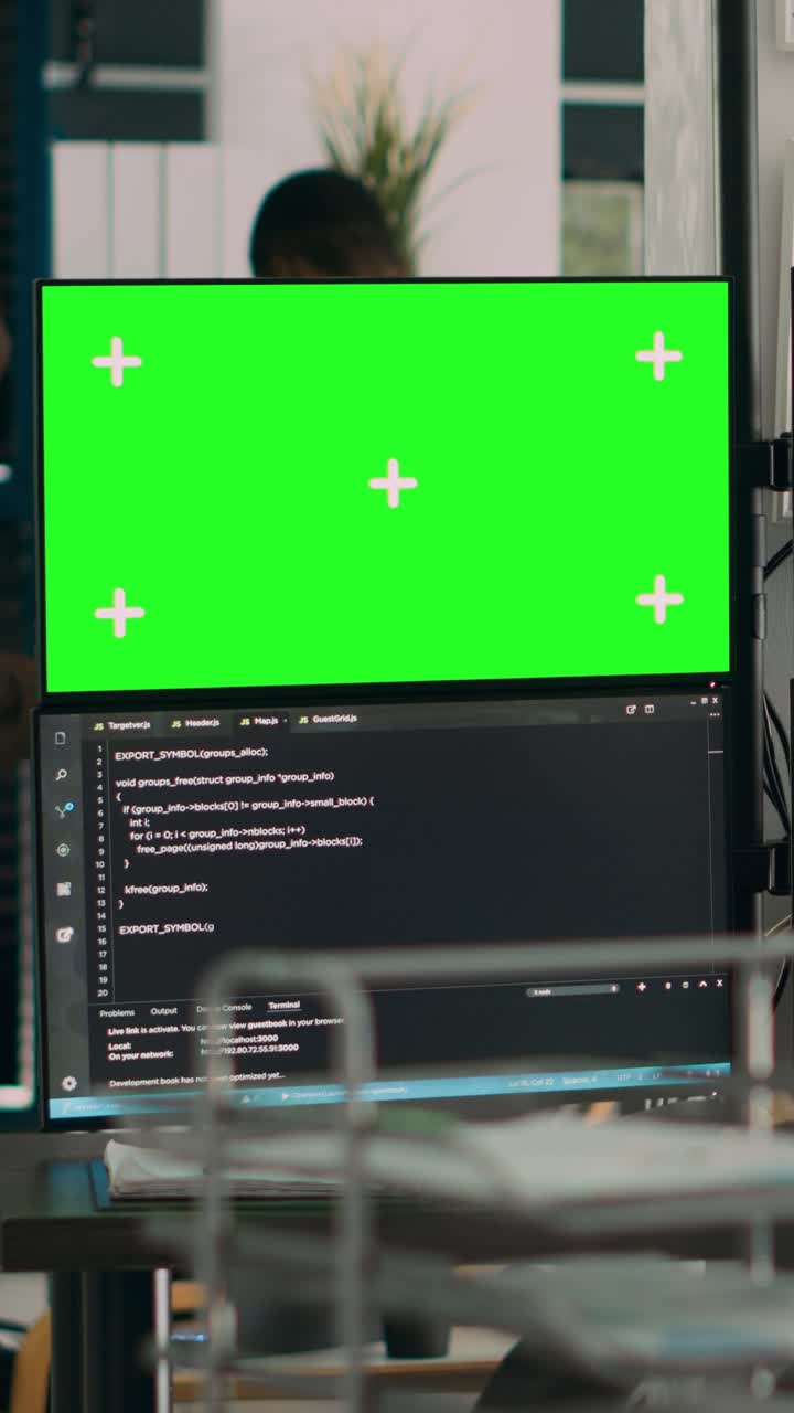 Vertical video: Woman programer looking at greenscreen and code on terminal window
