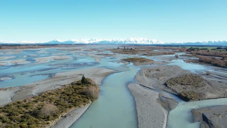 aerial descent showing how beautiful rakaia river cuts through vast landscape on it's journey from mountains to sea