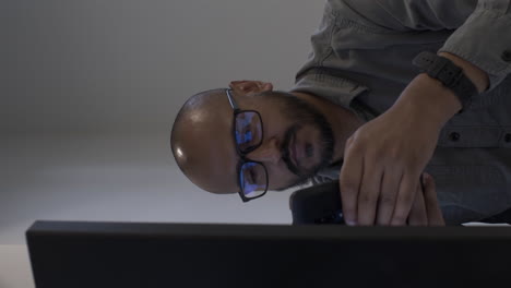 hombre asiático moderno del reino unido en la oficina usando un teléfono móvil en el escritorio