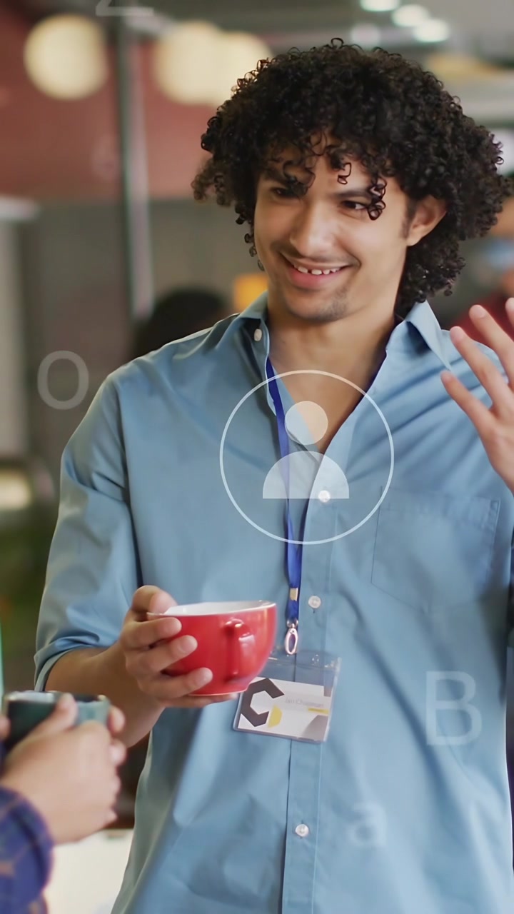 Vertical video: Man with red mug gesturing, laughing after peer speaks, office UI circling hands