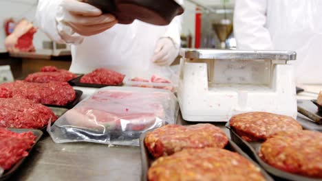 butcher checking the weight of meat