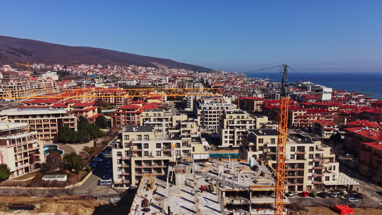 Vista Aérea de um Canteiro de Obras com Guindaste em uma Cidade Costeira