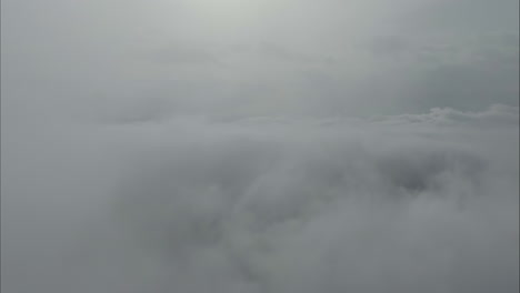 flying through thick fog and white clouds during winter